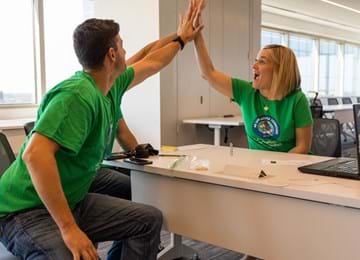 Coworkers High Five in Office